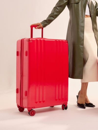 Studio product shot of front-facing CALPAK Ambeur large 30-inch hardshell luggage with 360 spinner wheels in metallic red; LAM1028-METALLIC-RED view 2