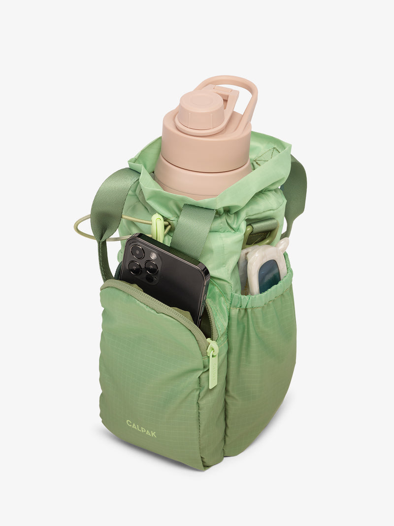 CALPAK Water Bottle Holder in green ombre Matcha with use of front phone pocket, side pocket with sunglasses and water bottle in main compartment