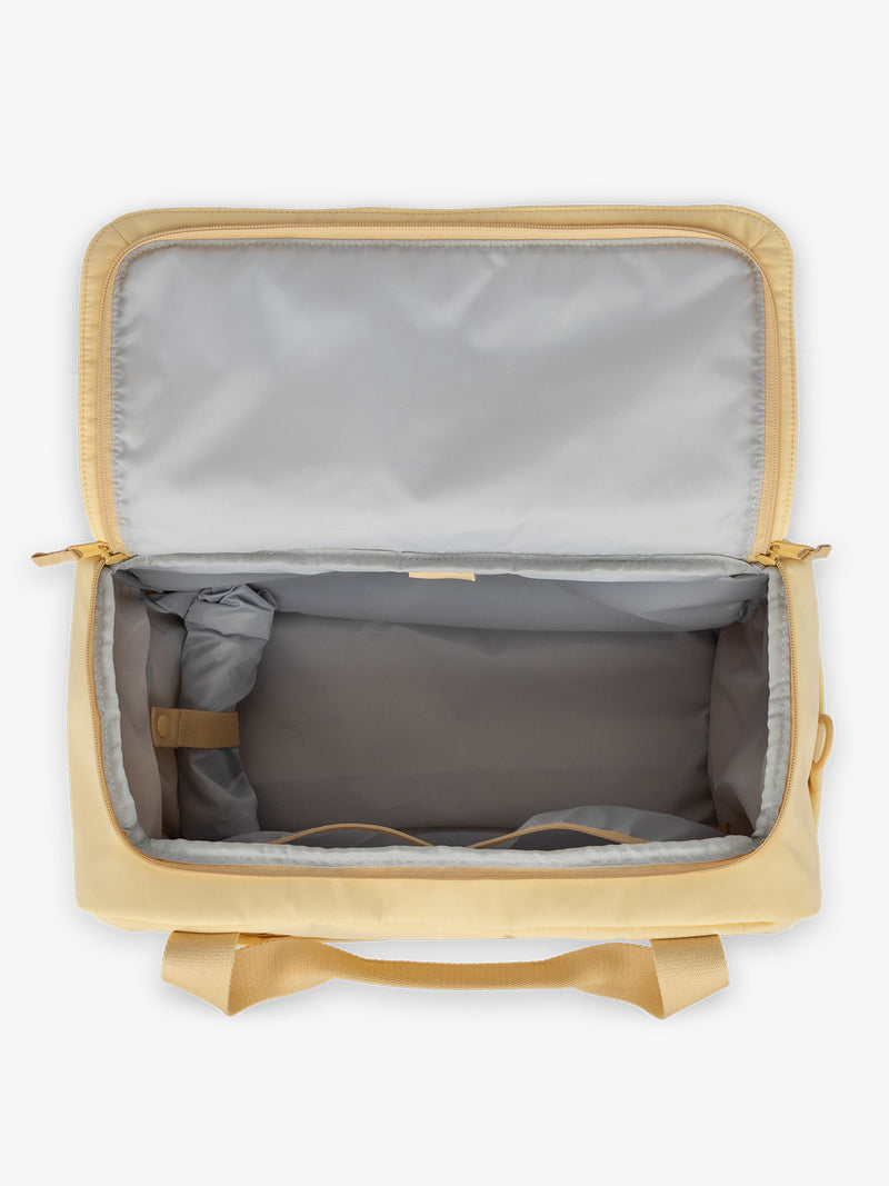 CALPAK Connect laptop duffel with multiple interior pockets and padded laptop sleeve with yellow exterior, gray interior