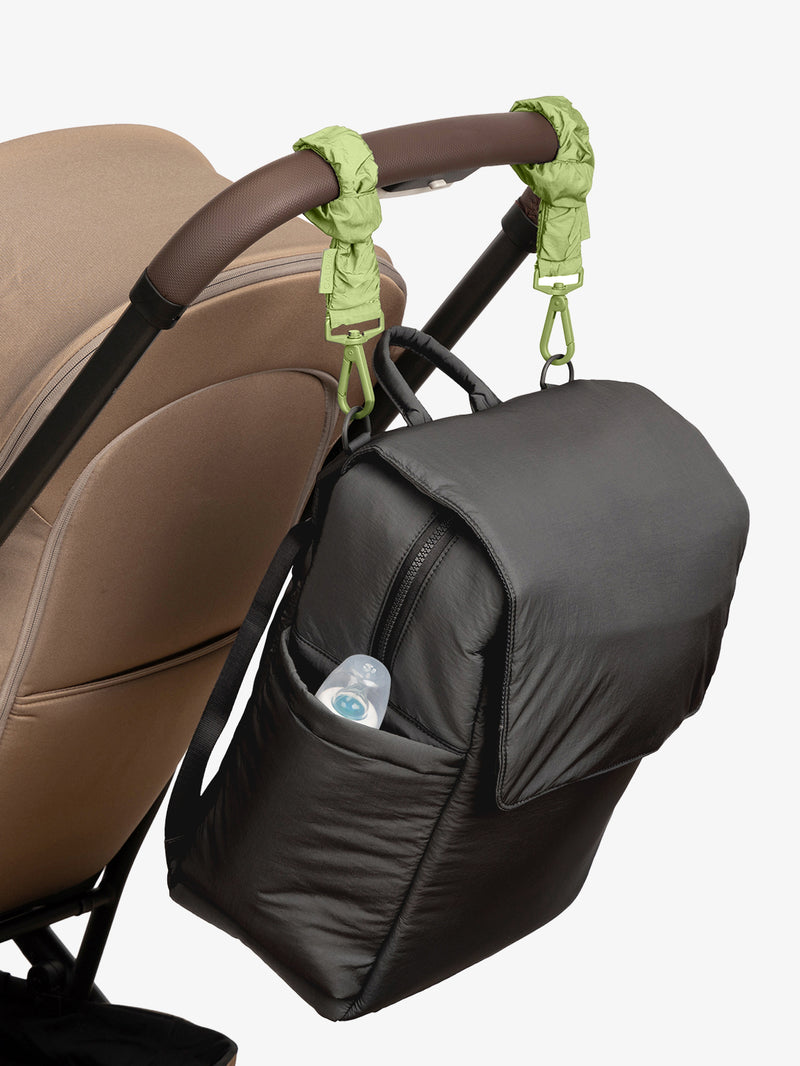 CALPAK Diaper Backpack in Black with light green Lime Stroller Straps attached to a brown stroller