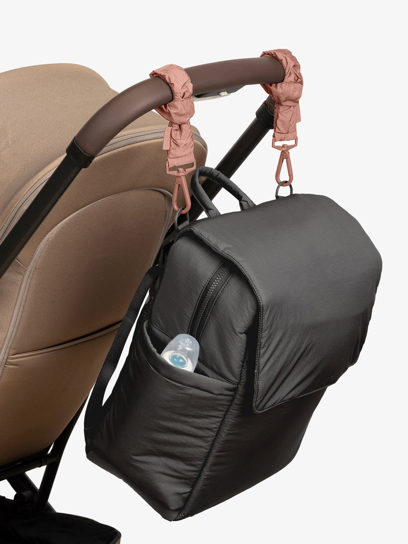 CALPAK Diaper Backpack in Black with pink Peony Stroller Straps attached to a brown stroller