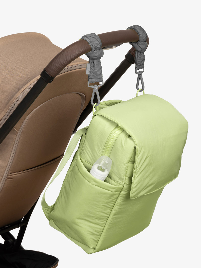 CALPAK Diaper Backpack in light green Lime with grey Slate Stroller Straps attached to a brown stroller