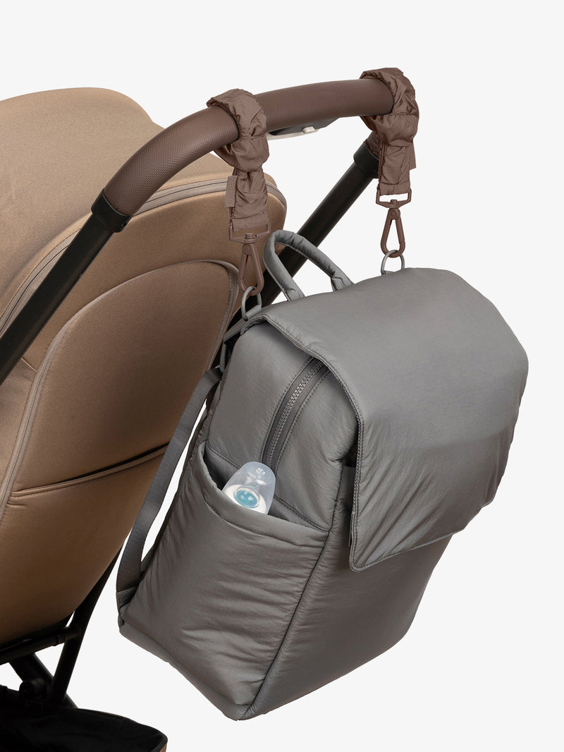 CALPAK Diaper Backpack in grey Slate with brown Hazelnut Stroller Straps attached to a brown stroller