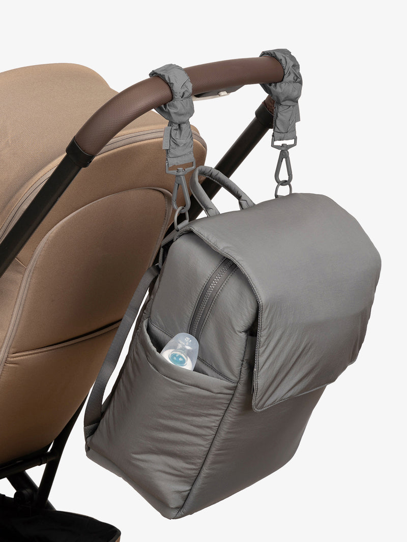 CALPAK Diaper Backpack in grey Slate with grey Slate Stroller Straps attached to a brown stroller