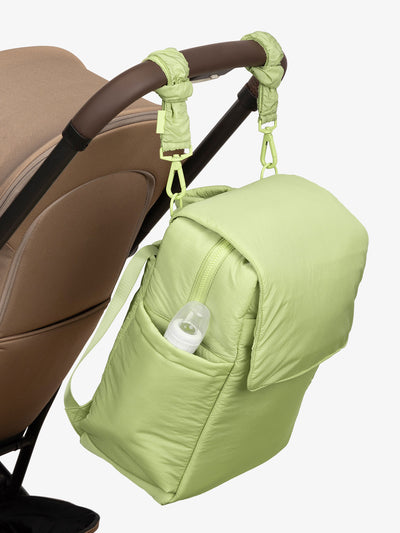 CALPAK Diaper Backpack with Laptop Sleeve attached to stroller by CALPAK Stroller Straps in lime; BPB2401-LIME, BBPB2401-LIME
