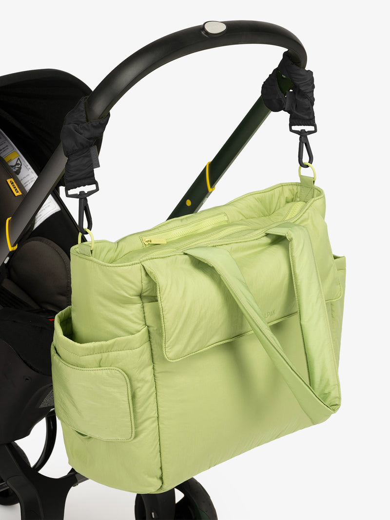 CALPAK Diaper Tote Bag in light green Lime with Black Stroller Straps attached to a black stroller