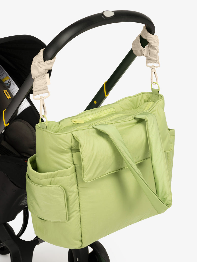 CALPAK Diaper Tote Bag in light green Lime with white Oatmeal Stroller Straps attached to a black stroller