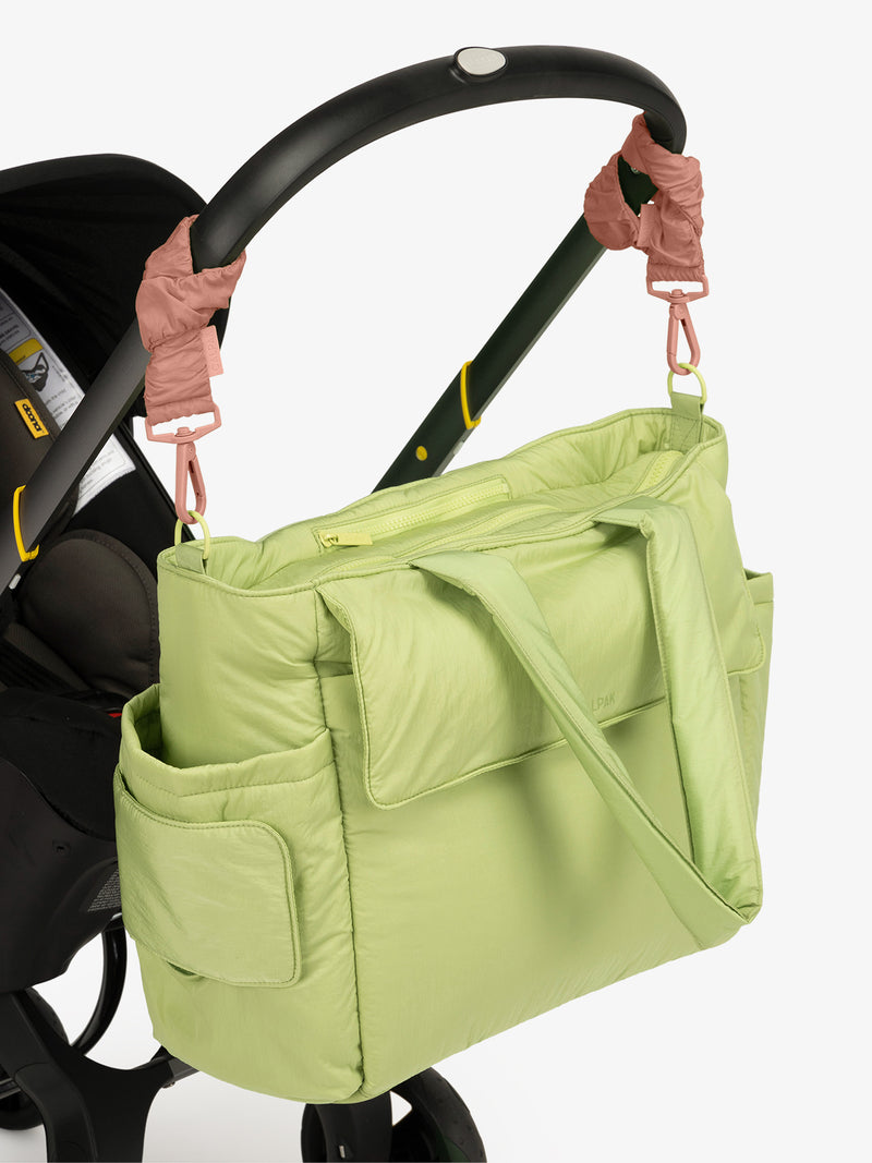 CALPAK Diaper Tote Bag in light green Lime with pink Peony Stroller Straps attached to a black stroller