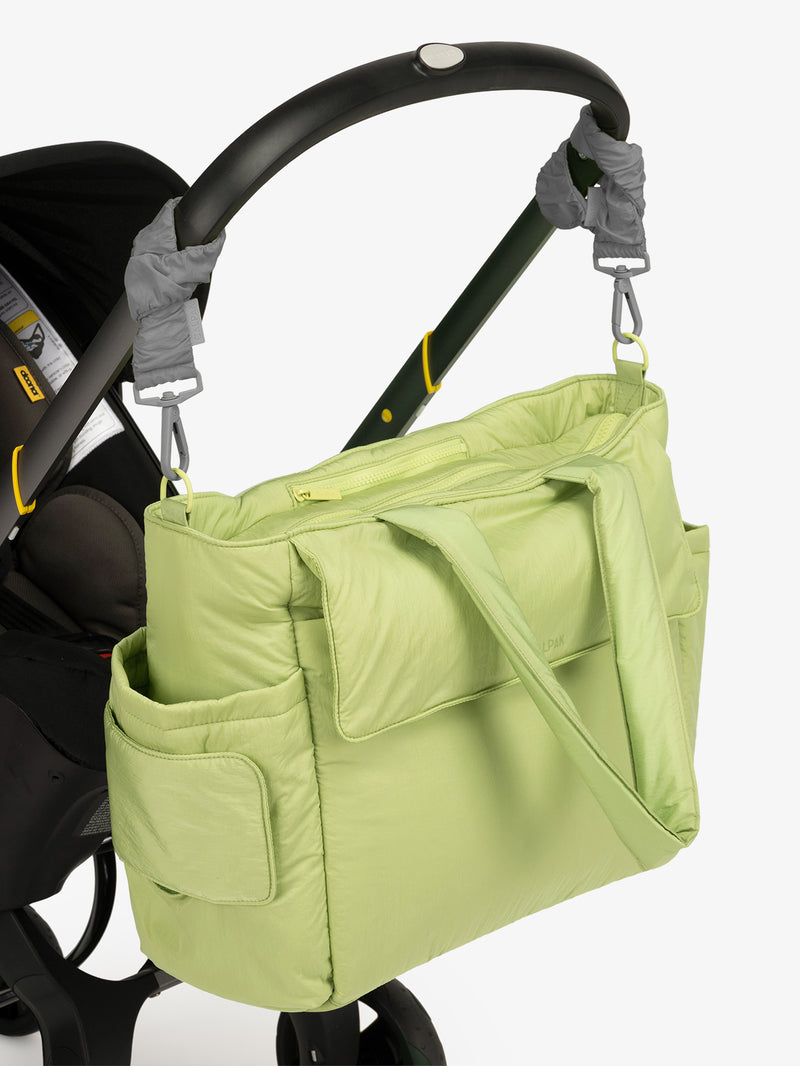 CALPAK Diaper Tote Bag in light green Lime with grey Slate Stroller Straps attached to a black stroller