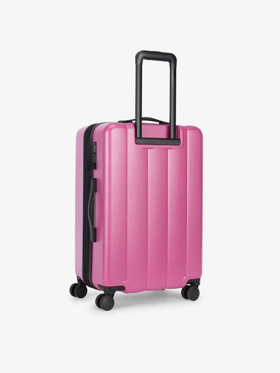 CALPAK medium luggage featuring dual spinner wheels and bottom grab handle in redish pink raspberry