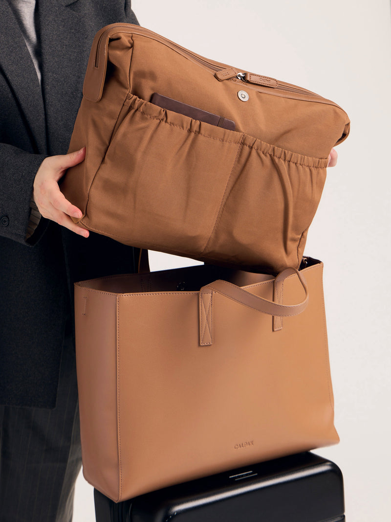 CALPAK Haven Laptop Tote Bag in brown Toffee with model carrying it on shoulder with shoulder strap