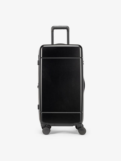 CALPAK Hue Medium Trunk Luggage with durable hard-shell exterior, cushioned top handle and 360 spinner wheels in black; LHU1026-BLACK