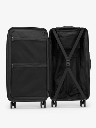 Medium Trunk Luggage by CALPAK with buckled elastic compression straps and zippered divider with multiple pockets in black