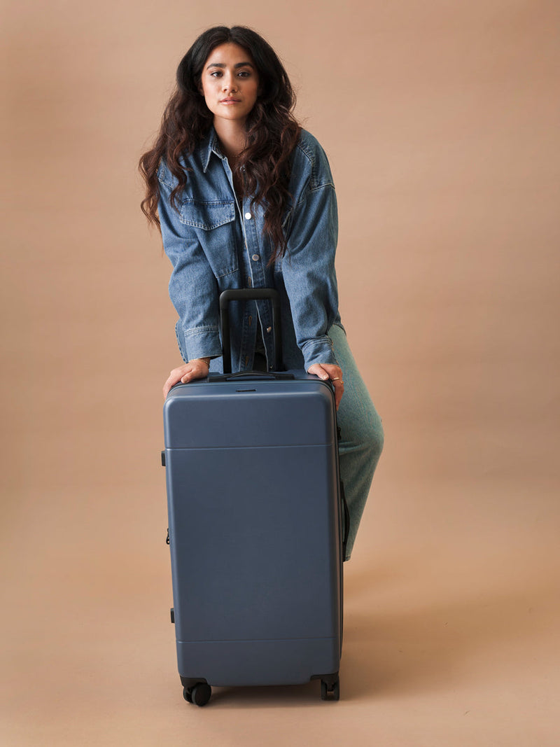 CALPAK model with Hue Trunk luggage in atlantic blue