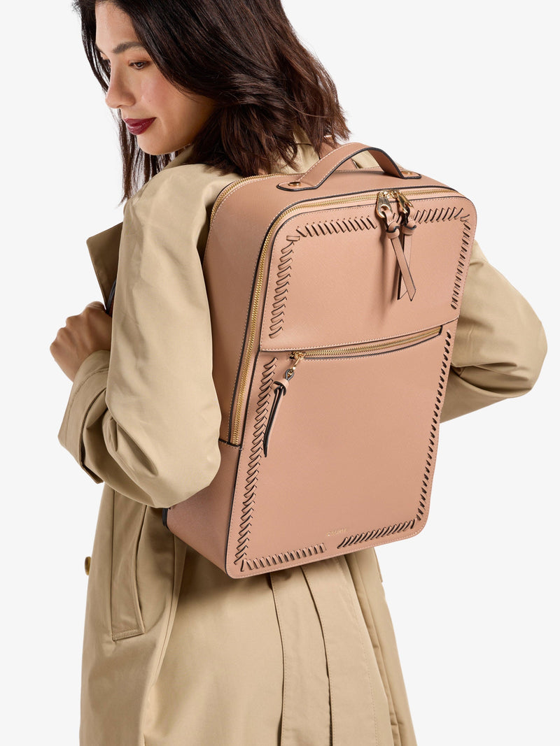 Model wearing brown CALPAK laptop backpack for 17 inch laptop