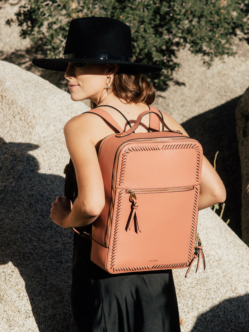 model holding terracotta CALPAK Kaya backpack