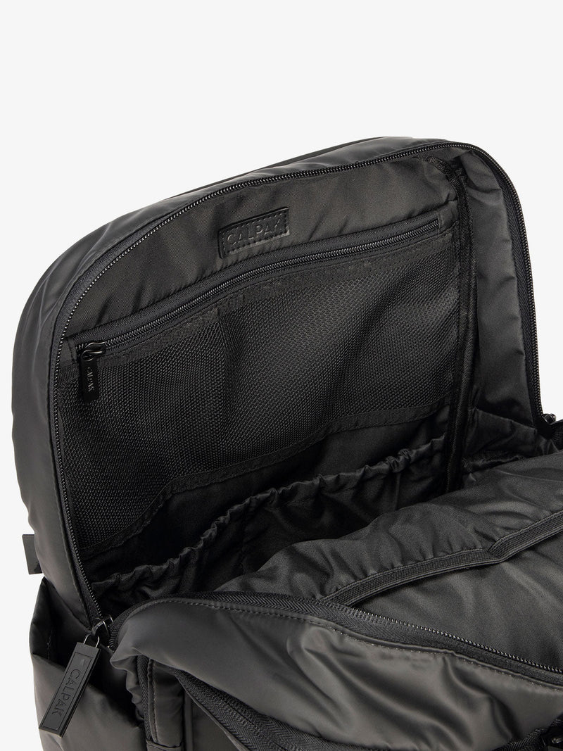 Close up of main compartment of CALPAK laptop backpack with multiple interior pockets in black