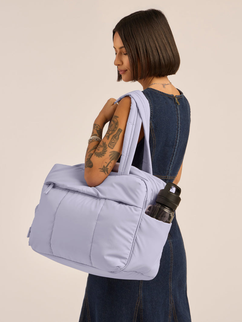 Model wearing CALPAK Luka Duffel monochrome purple lavender Orchid with straps