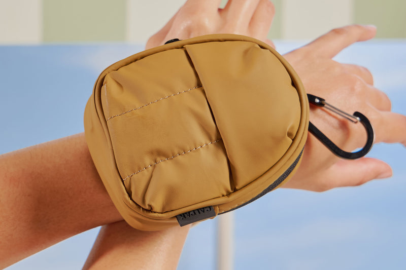 Luka Key Pouch soft puffy exterior on wrist in khaki