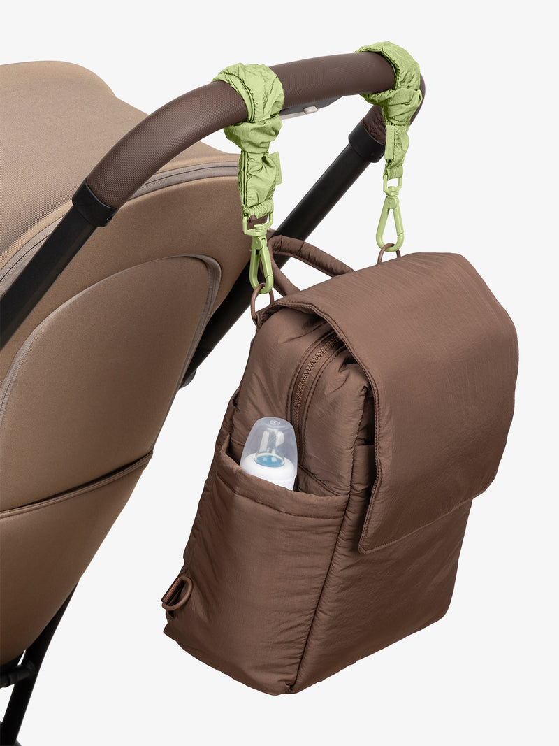 CALPAK Convertible Mini Diaper Backpack in brown Hazelnut with light green Lime Stroller Straps attached to a brown stroller