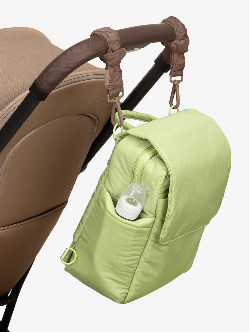 CALPAK Convertible Mini Diaper Backpack in light green Lime with brown Hazelnut Stroller Straps attached to a brown stroller