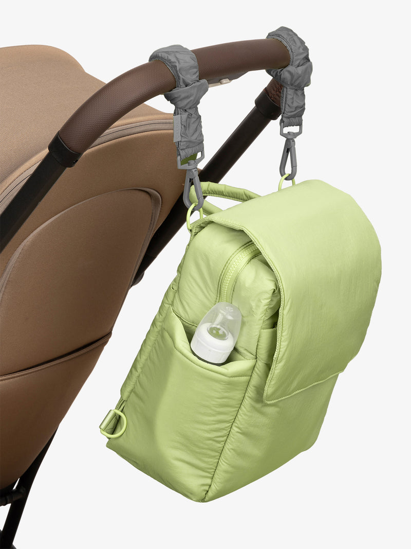 CALPAK Convertible Mini Diaper Backpack in light green Lime with grey Slate Stroller Straps attached to a brown stroller