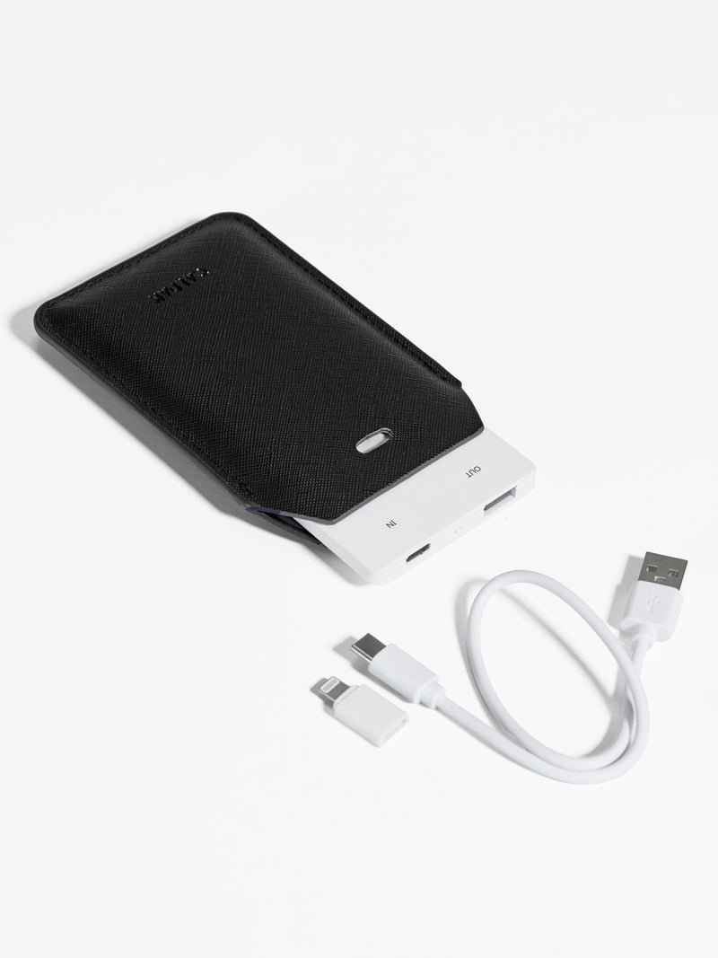 Black CALPAK Portable Luggage Tag + Charger featuring included cord, USB-C and Lighting adaptor compatibility and 2500 mAh battery power