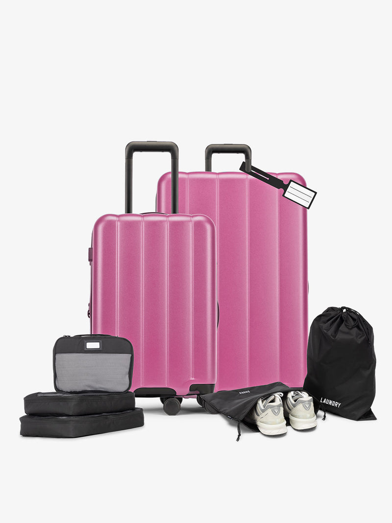 CALPAK starter bundle with carry-on, large luggage, packing cubes, pouches, and luggage tag in raspberry