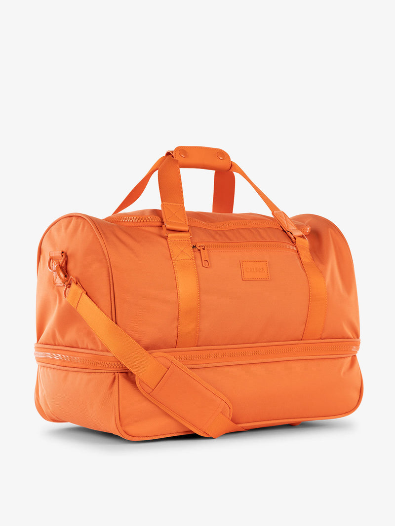 CALPAK Stevyn Duffel bag with removeable padded crossbody strap in orange