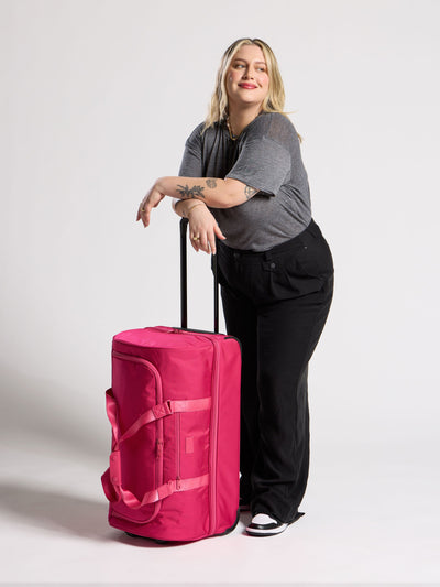 Side view of CALPAK Stevyn Large Rolling Duffel in dragonfruit pink; DRL2301-DRAGONFRUIT view 2