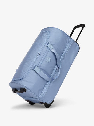 Side view of sky blue CALPAK large rolling travel duffel bag with wheels; DRL2301-SKY view 1