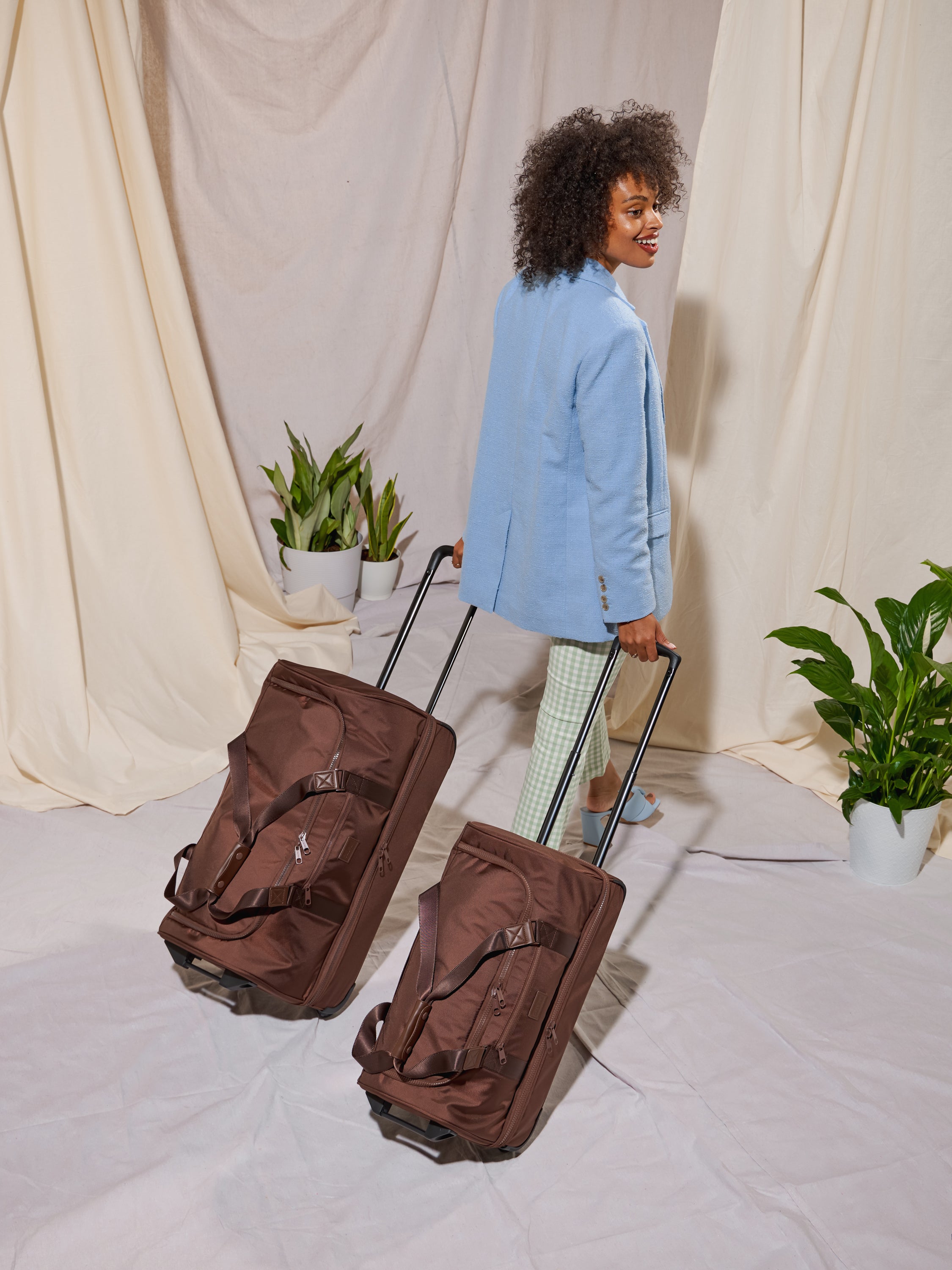 https://www.calpaktravel.com/cdn/shop/files/STEVYN-LARGE-ROLLING-DUFFEL-WALNUT-LIFESTYLE1.jpg?v=1689204796&em-format=avif