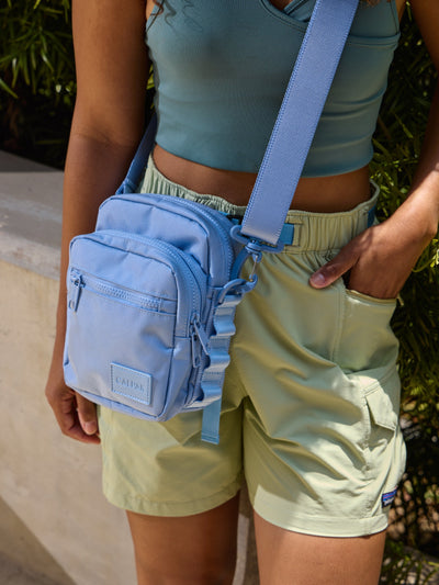 Front-view of CALPAK Stevyn Mini Crossbody Bag with zippered pockets and side panel daisy chains in sky blue; ACS2301-SKY view 2