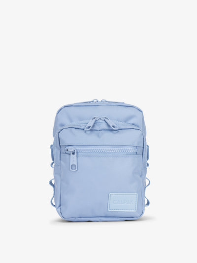 Front-view of CALPAK Stevyn Mini Crossbody Bag with zippered pockets and side panel daisy chains in sky blue; ACS2301-SKY view 1