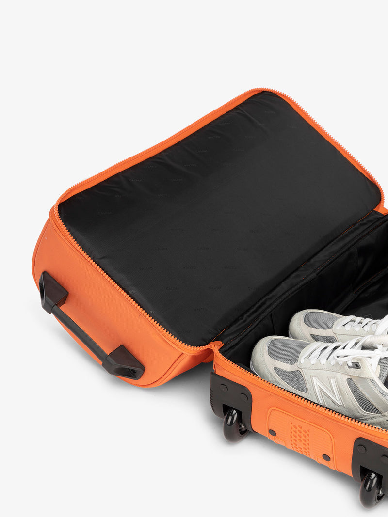 CALPAK Stevyn Rolling Duffle interior of shoe compartment in orange