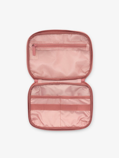 Interior view of CALPAK tech organizer in pink tea rose with loops and zippered pockets for organizing electronics and belongings