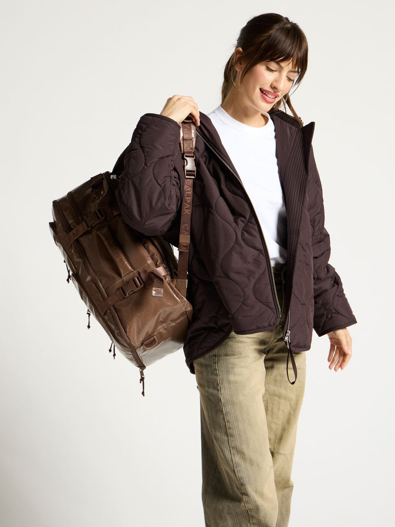 Model wearing CALPAK 26L Laptop Backpack Duffel in cacao