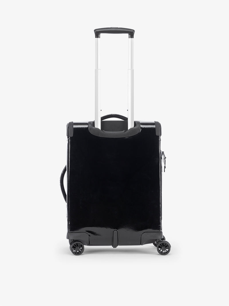 Studio product shot of back-facing CALPAK Terra 35L Carry-On luggage with soft shell and 360 spinner wheels in obsidian black