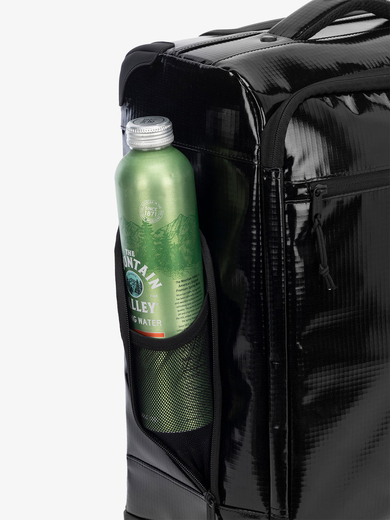 Studio product shot of side bottle holder pocket of CALPAK Terra 35L Carry-On luggage with soft shell and 360 spinner wheels in obsidian