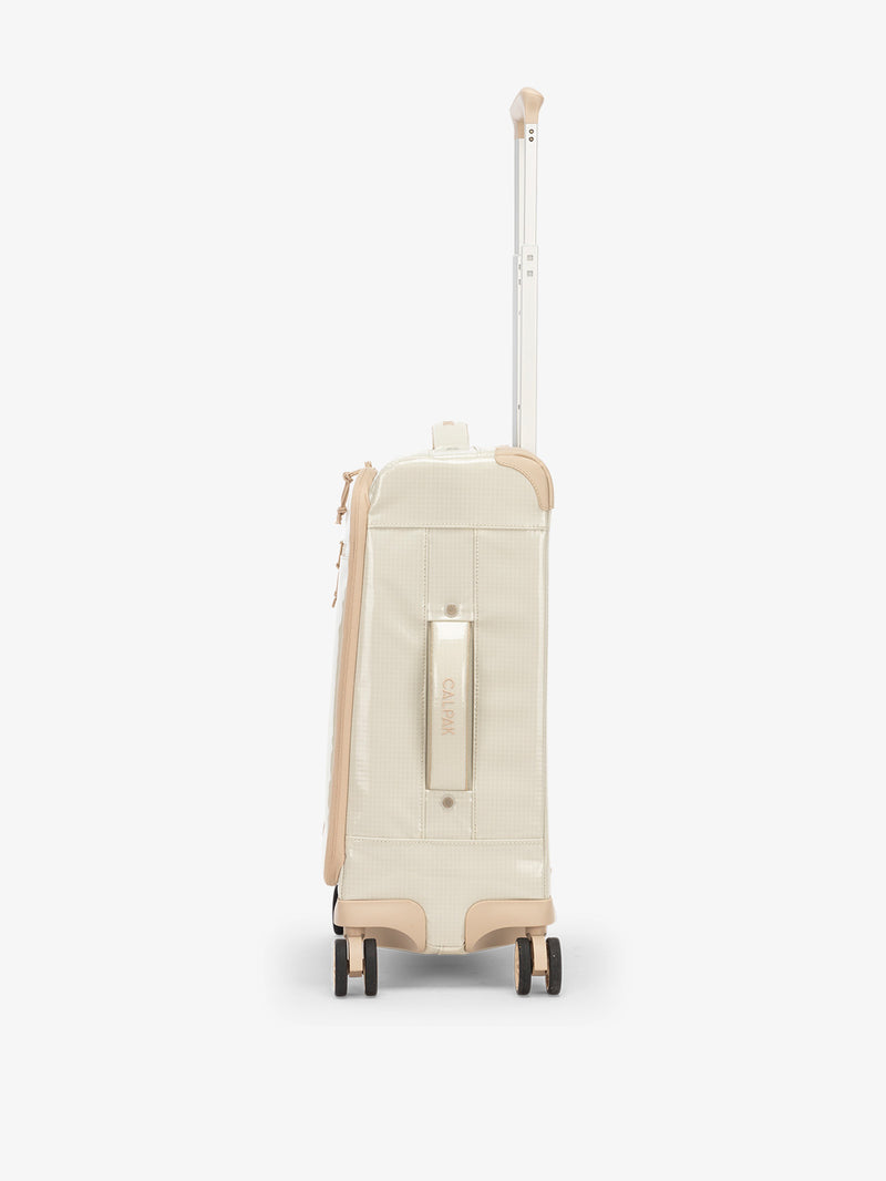 Studio product shot of side-facing CALPAK Terra 35L Carry-On luggage with soft shell and 360 spinner wheels in beige