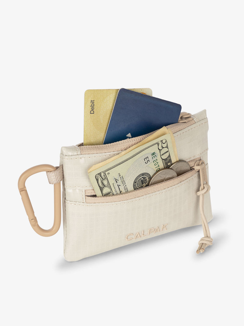 White sands CALPAK Terra Clippable Card Pouch with cards in main pocket and a $20 dollar bill and coins in the front pocket