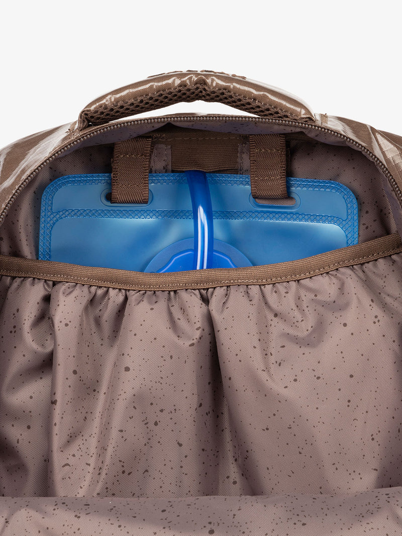 Close up of CALPAK 2L removable hydration reservoir back-slip pocket in brown cacao