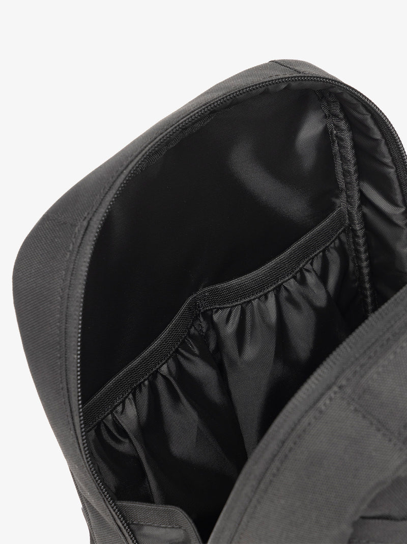 Interior view of CALPAK The Everything Cube featuring water resistant lining and interior pockets in black