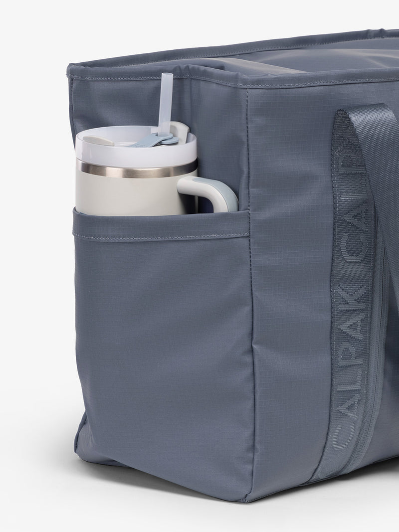 CALPAK Terra 35L Water Resistant Zippered Tote Bag in blue Matte Indigo side pocket used as as water bottle holder