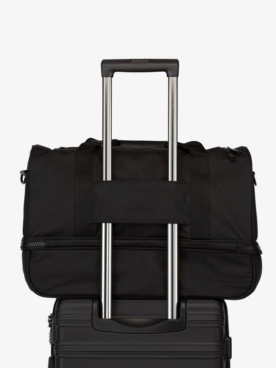 black CALPAK Stevyn duffel bag with luggage trolley sleeve