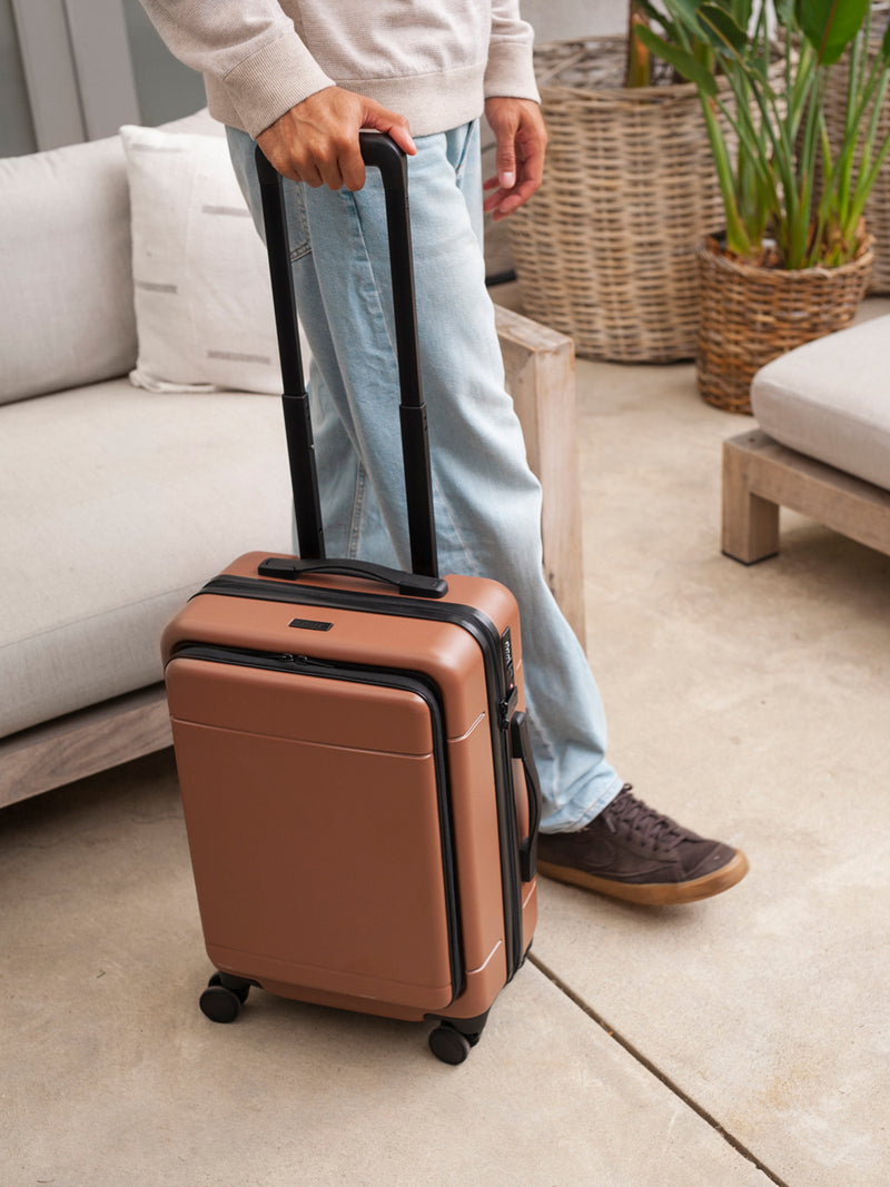 CALPAK Hue hard shell carry-on spinner luggage with laptop compartment in brown hazel color