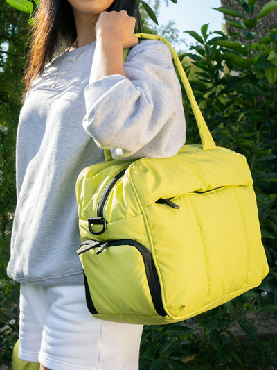 Model pictured with CALPAK Luka duffel bags in celery green and green apple